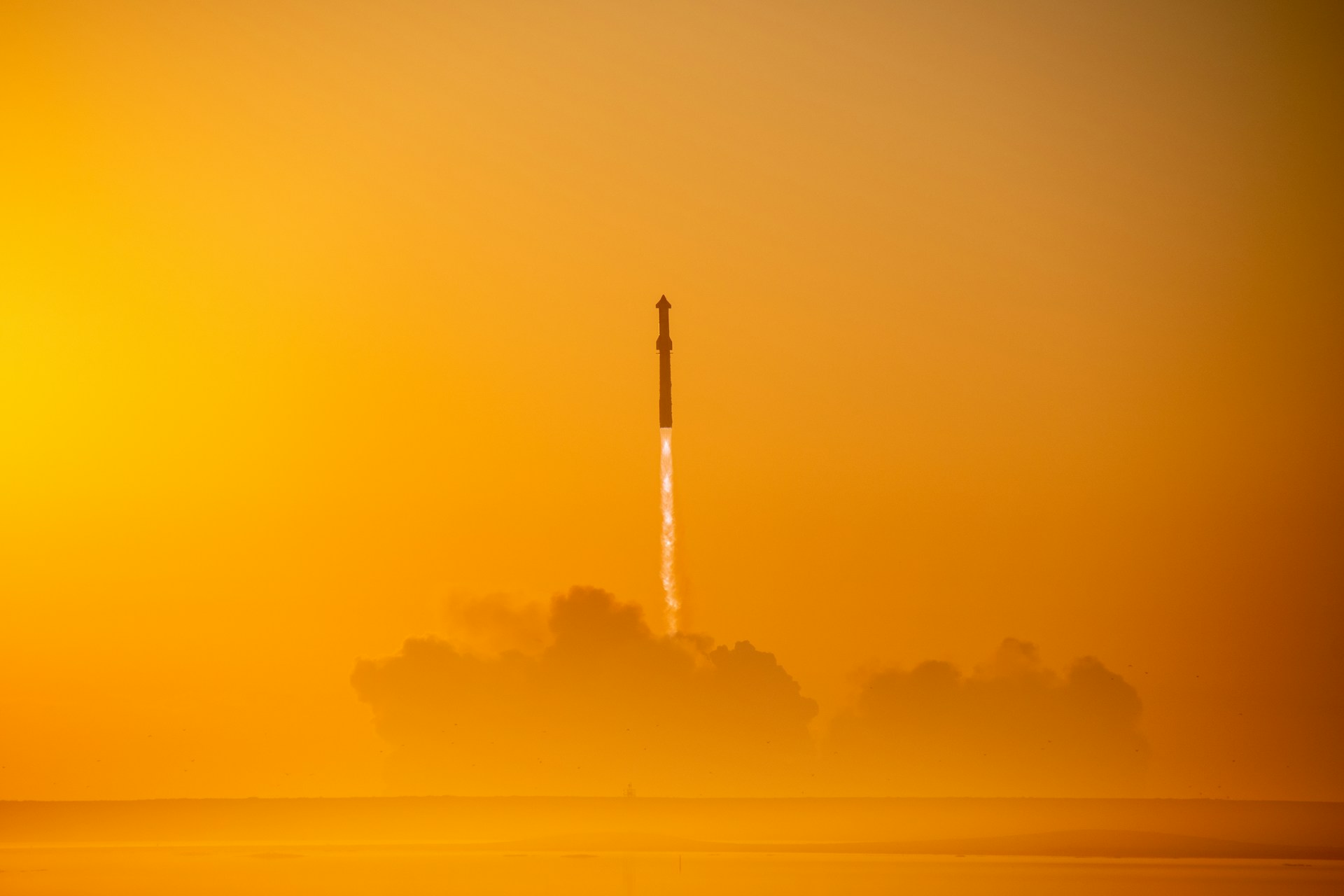 Rocket launching into an orange hazy sky at dusk